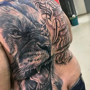 Tatuagem realismo preto e cinza de leão com lettering nas costas