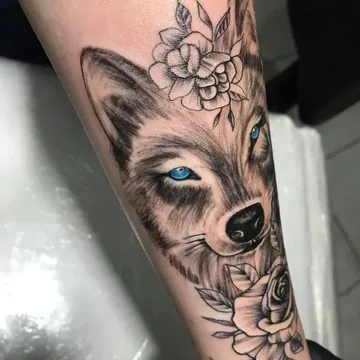 Tatuagem realismo preto e cinza de lobo com flores no antebraço