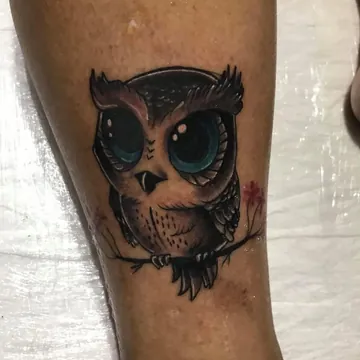 Tatuagem cartoon colorida de coruja na perna