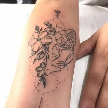 Tatuagem fineline de leoa com flores e flecha no antebraço