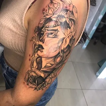 Tatuagem preto e cinza de Medusa com rosa no braço