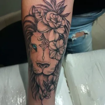 Tatuagem fineline de leão com flores no antebraço